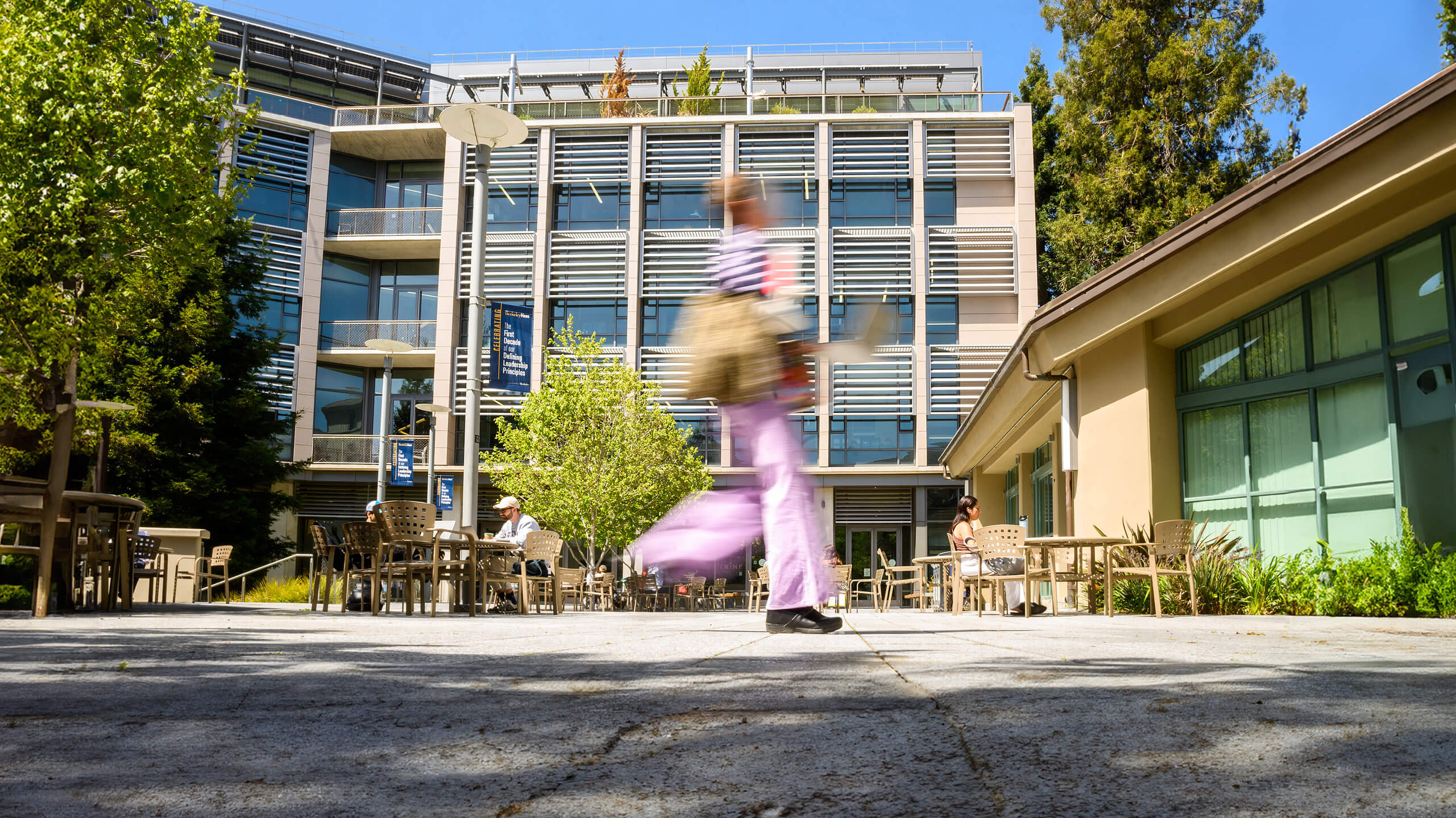 Image of person walking in front of Chou Hall on Haas Campus